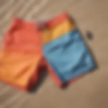 Vibrant board shorts laid out on a sandy beach