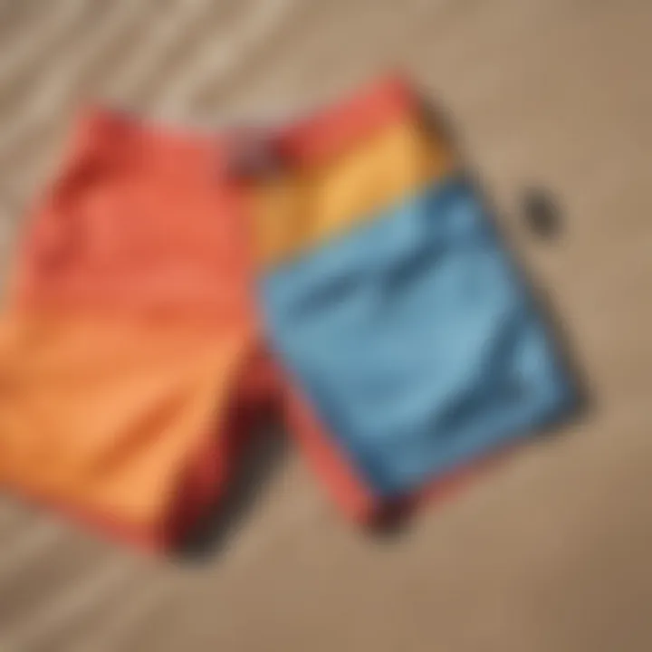 Vibrant board shorts laid out on a sandy beach