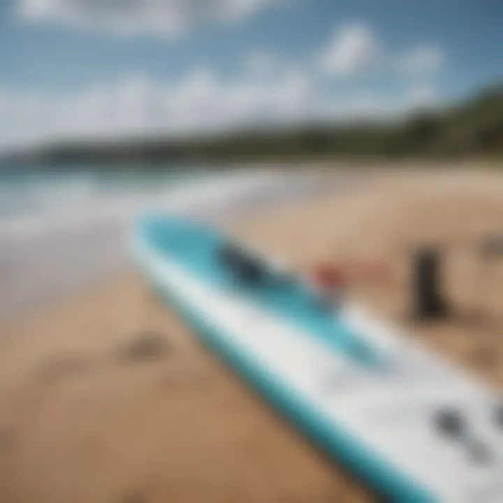 A close-up of essential paddle board gear laid out on a sandy shore