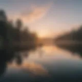 A serene lake at dawn with a paddle boarder gliding across the water