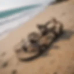 A pair of stylish surf sandals resting on a sandy beach