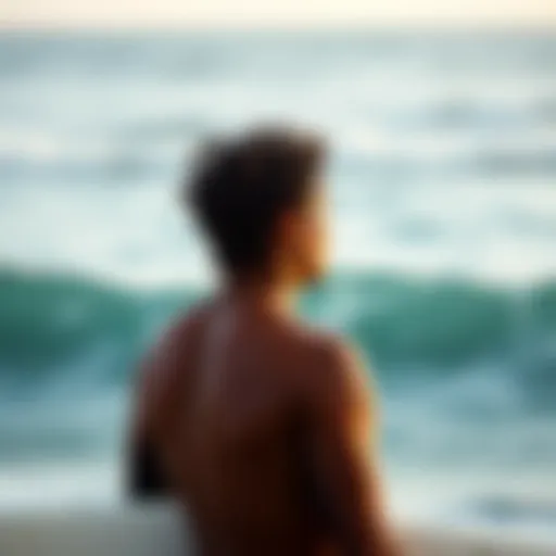 A surfer observing ocean swells in a thoughtful manner.