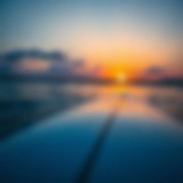 Close-up of surfboard with sunset reflection in the water